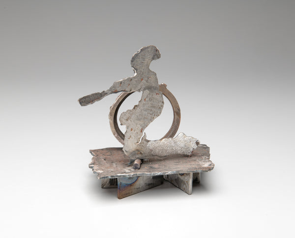 Metal abstract sculpture of a person and a circle against a gray background