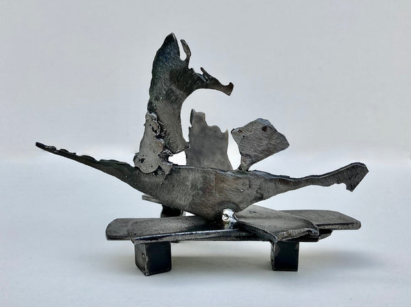 Abstract steel sculpture depicting a boat and rock.