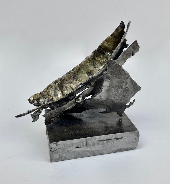 Abstract metal sculpture of a boat on a square base.