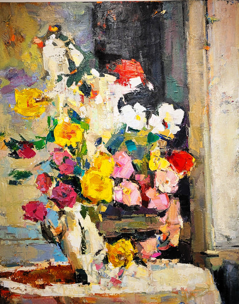 Colorful floral arrangement in a vase on a textured surface