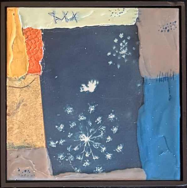 Art piece with a central dark blue panel featuring white floral patterns, surrounded by colorful edges.