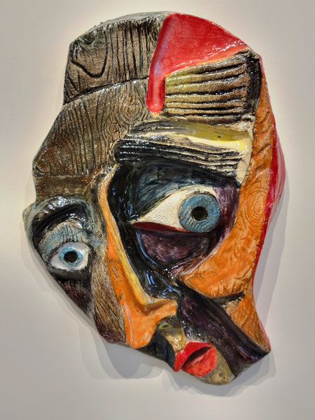 Abstract ceramic face sculpture on a white background