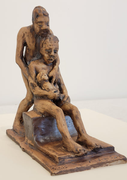 Sculpture of a man and woman holding a child on a white background