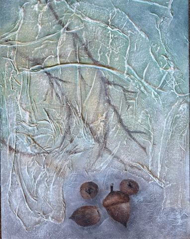 Three acorns on a textured surface with a blurred background