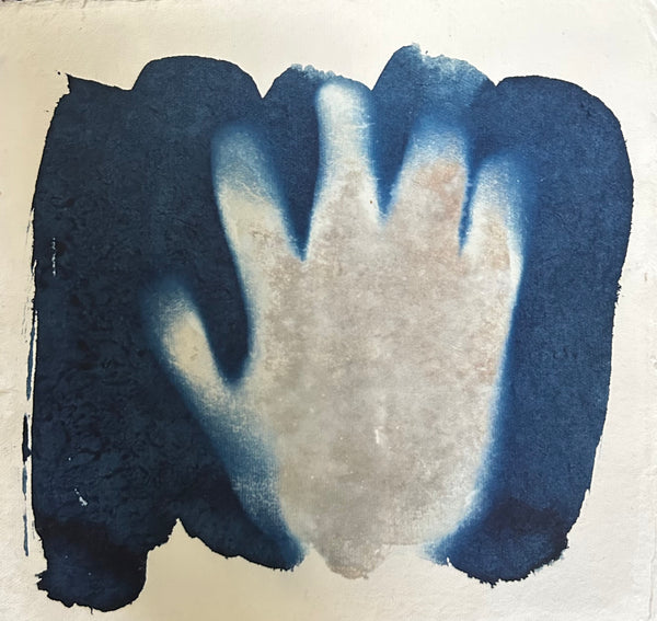 Abstract cyanotype print with a handprint on a blue background