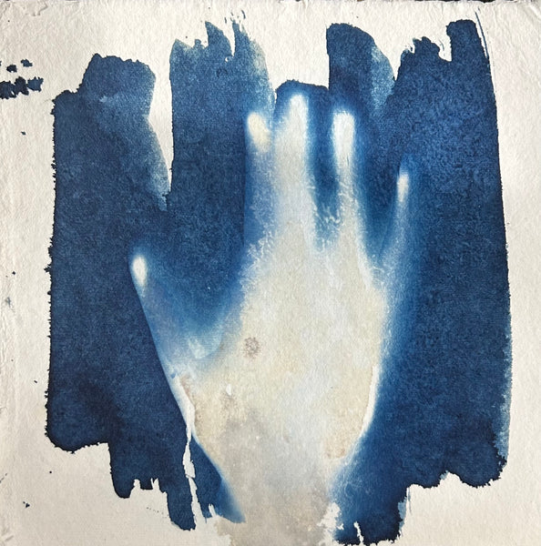 Abstract cyanotype print of a hand with blue and white brush strokes