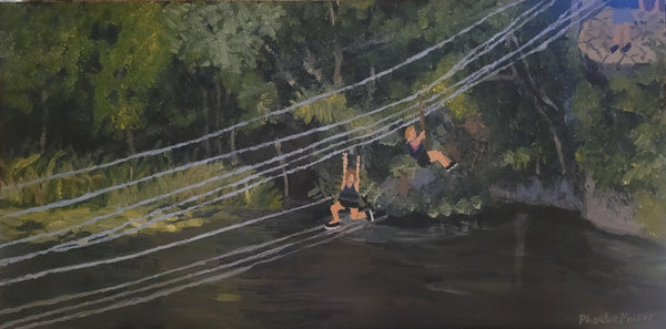 Two people on a zip line over water with trees in the background