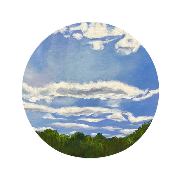Round painting of a blue sky with white clouds and green trees at the horizon.