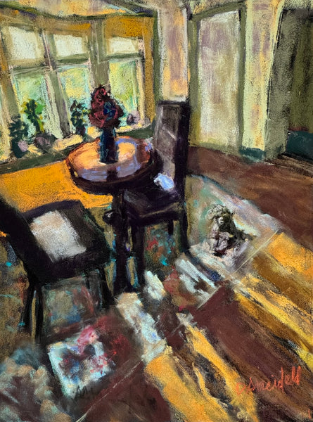 An impressionistic pastel painting of a cozy interior room with a round wooden table, two dark chairs, a window with yellow light, and a small figurine on the floor. The artwork features expressive brushstrokes in warm yellows, browns, creams, and soft blues, signed 'Schmid' in the lower right corner.