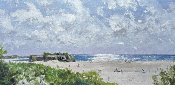 Beach scene with people and a large ship, under a blue sky with white clouds.