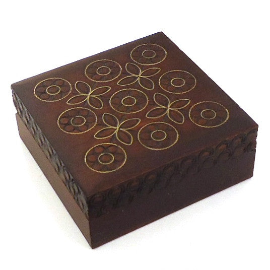 A brown wooden box with geometric patterns carved on the lid.
