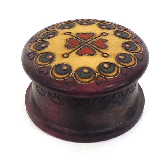 Carved and stained wood round box with heart pattern on lid.