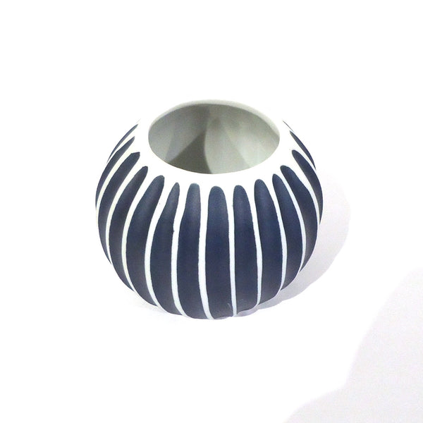 Asymmetrical ribbed porcelain vase in deep blue with bold white stripes available at Cerulean Arts.