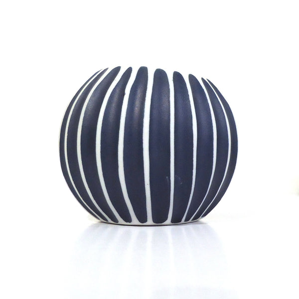 Asymmetrical ribbed porcelain vase in deep blue with bold white stripes available at Cerulean Arts.