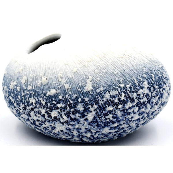 Pebble-shaped porcelain bud vase with rough frosted texture in blue fading to white available at Cerulean Arts.  