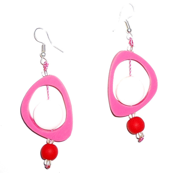 Bold fuchsia ovoid resin earrings with white circles, accented with red beads available at Cerulean Arts. 