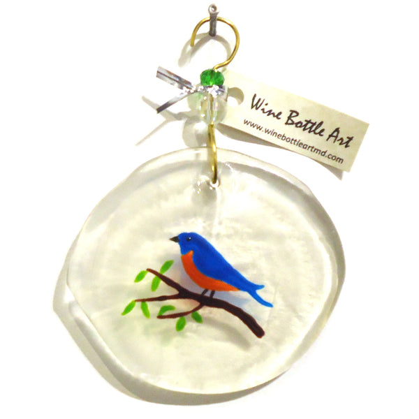 Clear glass suncatcher with blue bird on a branch made from a recycled wine bottle available at Cerulean Arts. 
