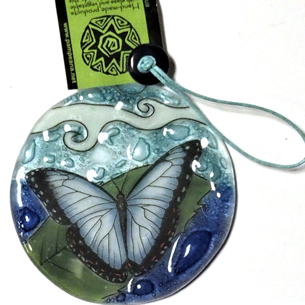 Fused glass suncatcher featuring a blue morpho butterfly on a leaf available at Cerulean Arts.