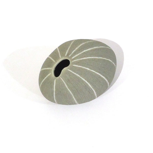 Pebble-shaped porcelain bud vase with rough matte texture in grey with white stripes available at Cerulean Arts. 